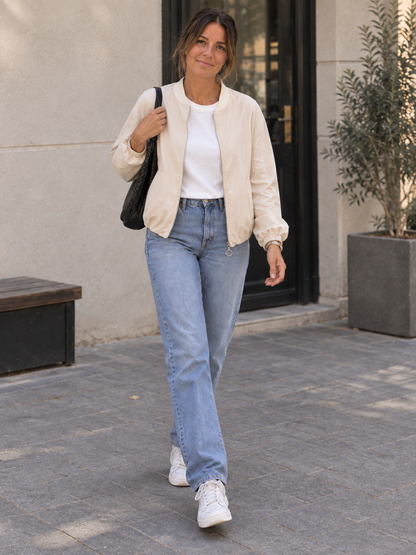 Creme Bomberjacke mit Ring-Zipper beim Gehen, Blick zur Kamera