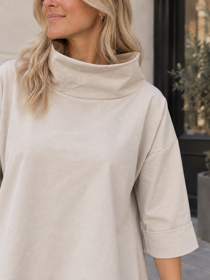 Oversize-Oberteil mit Stehkragen in Beige – Detail von Kragen und Ärmel