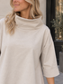 Oversize-Oberteil mit Stehkragen in Beige – Detail von Kragen und Ärmel