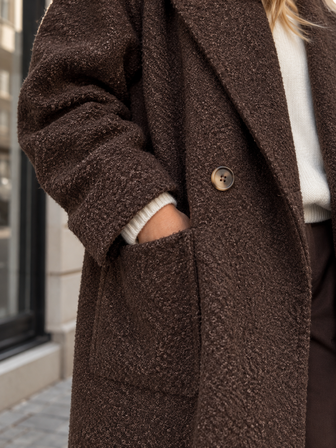 Weicher Mantel in Dunkelbraun – Detail von Revers, Knopf und Tasche