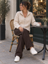 Creme beige gestreifter Zip Cardigan für Damen im Straßencafé